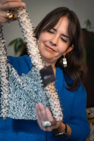 Unternehmerin Karin checkt eine Tasche auf ihre Qualität