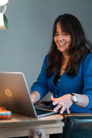 Unternehmerin und Mutter Karin G. sitzt am Computer-Arbeitsplatz mit Babyphone auf dem Tisch