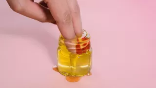 Finger in einem Honigglas, welches überläuft